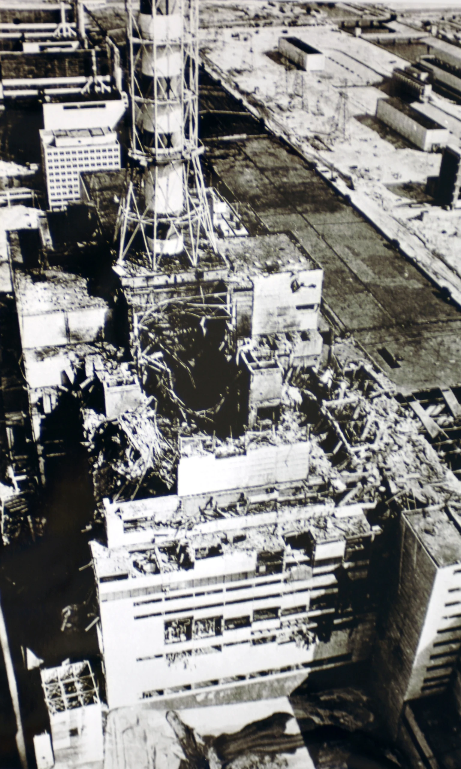 Chernobyl disaster, nuclear accident, aerial view, power plant, aftermath, radioactive release, structural damage, desolate landscape, historical photograph, environmental disaster